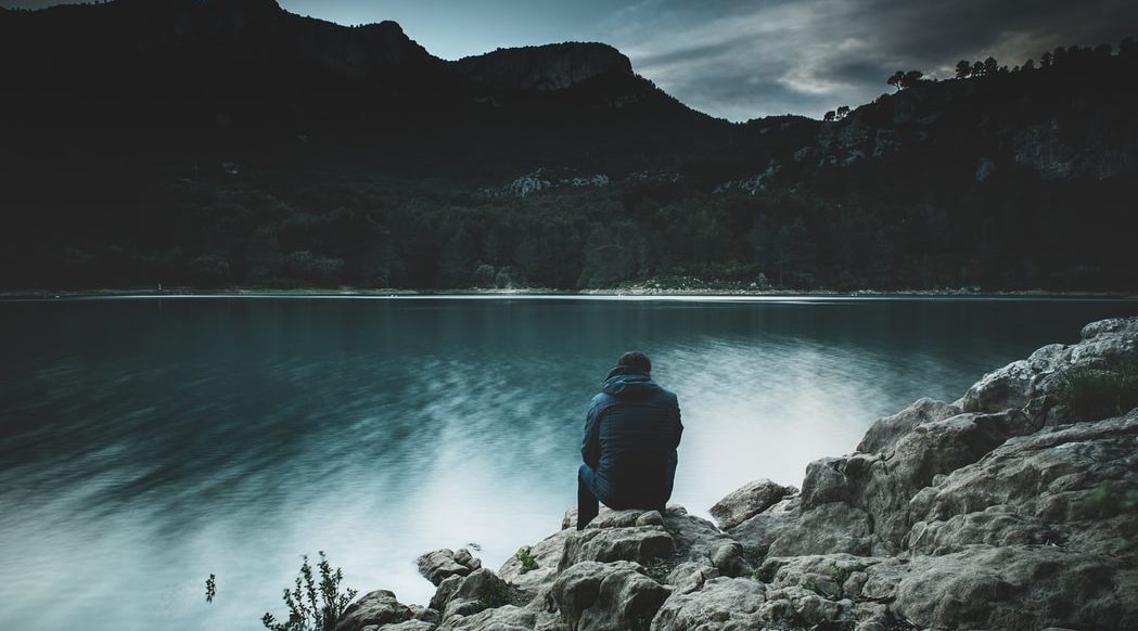 Man Sitting Alone by Water