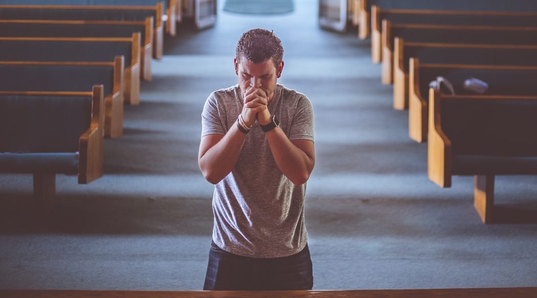 Man Praying at front of church